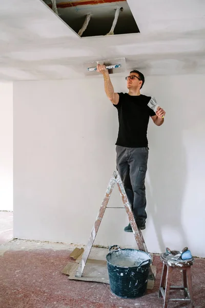 Plasterer smoothing plaster ceiling with the trowel — Stock Photo, Image