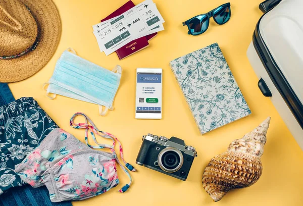 Conjunto com passaporte covid móvel e objetos de férias na praia — Fotografia de Stock