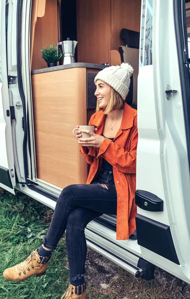 Femme buvant du café assis à la porte d'un camping-car — Photo