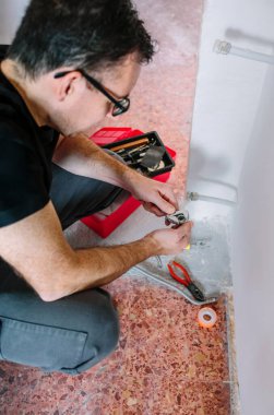 Tesisatçı ısıtma için anahtarı ayarlıyor