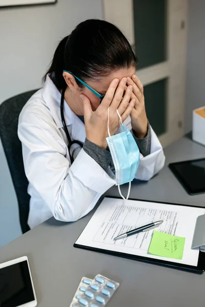 Kvinnlig läkare med pandemisk trötthet som täcker ansiktet — Stockfoto
