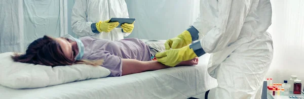 Médecins prélevant des échantillons de sang d'un patient allongé sur un brancard — Photo