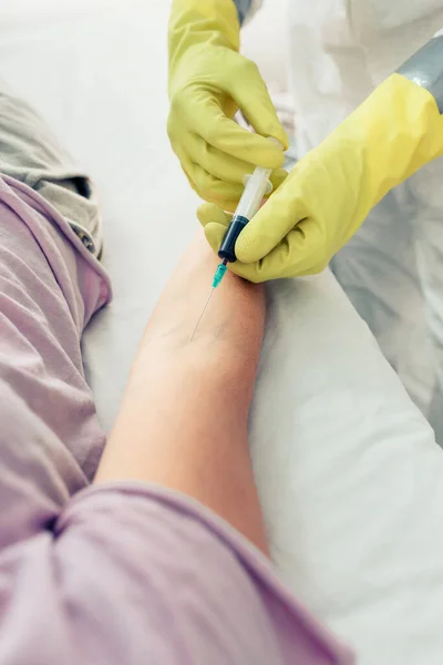 Dokter doet bloedonderzoek bij patiënt liggend op de brancard — Stockfoto