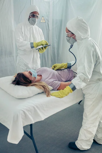 Médicos em um hospital de campo examinando um paciente — Fotografia de Stock