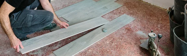 Metselaar plaatsen van tegels om een vloer te installeren — Stockfoto
