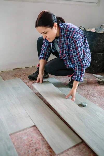 Female bricklayer placing tiles to install a floor — Stock Photo, Image