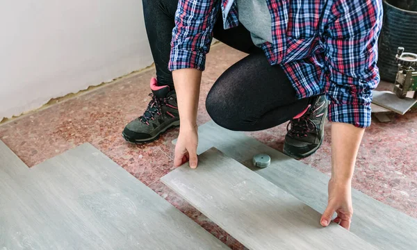 Female bricklayer placing tiles to install a floor — Stock Photo, Image