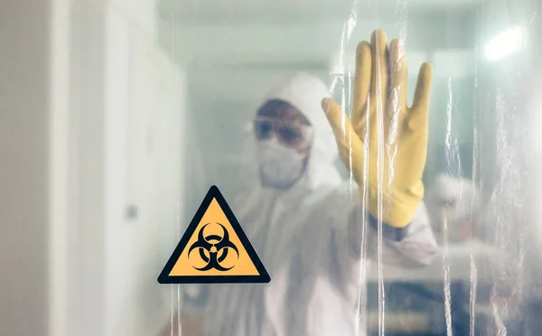 Biohazard symbool met onherkenbare arts die doorgang verbiedt — Stockfoto