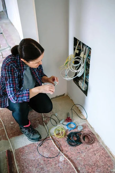 Ženský technik se šroubovákem a svorkovnicí instalující telekomunikační box — Stock fotografie