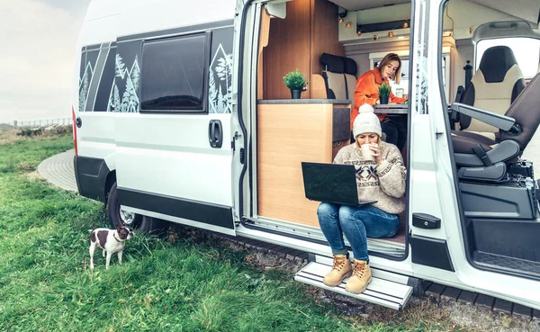 Donna telelavoro bere caffè seduto alla porta di un camper — Foto Stock