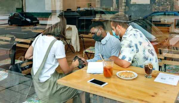 Друзья смотрят на планшет, сидящий в кафе — стоковое фото