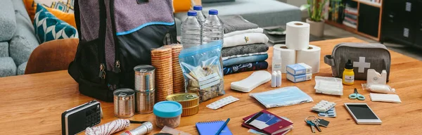 Equipo de mochila de emergencia organizado sobre la mesa —  Fotos de Stock