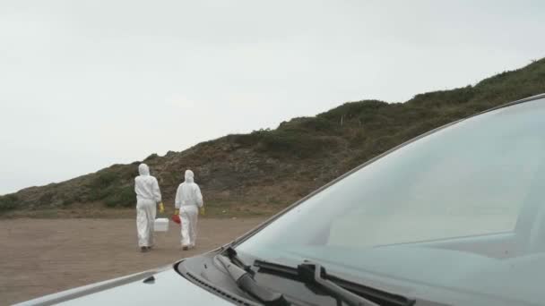 Unrecognizable scientists with bacteriological equipment walking outdoors — Stockvideo