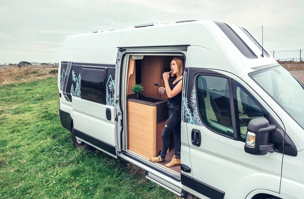 Woman brushing teeth in the morning at the door of her campervan — Foto Stock