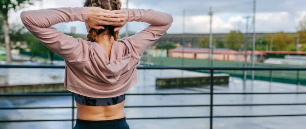 Jonge sportvrouw stretching nek en schouders buiten — Stockfoto