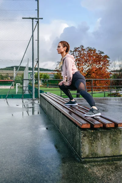 Joven deportista estirando piernas al aire libre — Foto de Stock