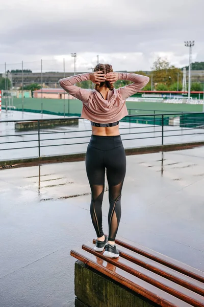 Joven deportista estirando cuello y hombros al aire libre — Foto de Stock