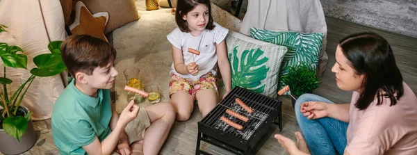 Vista superior de la familia asando y comiendo salchichas en la barbacoa —  Fotos de Stock