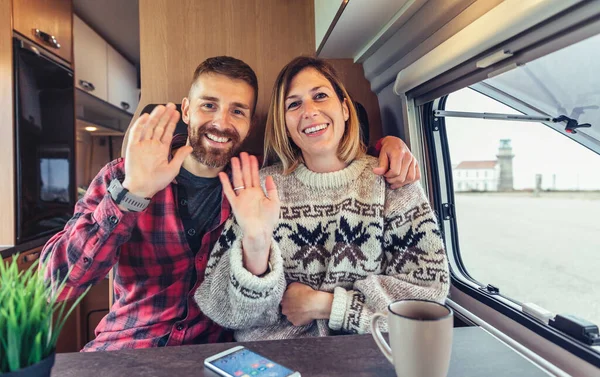Couple waving looking at camera on video call from their camper van — Stock Photo, Image