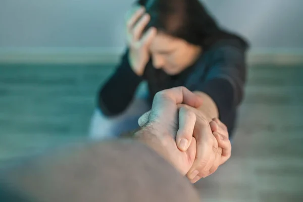 Donna irriconoscibile con problemi di salute mentale che riceve aiuto dall'uomo che le tiene la mano — Foto Stock