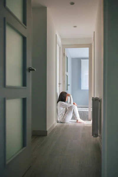 Mulher de pijama sentada no chão de um centro de saúde mental — Fotografia de Stock
