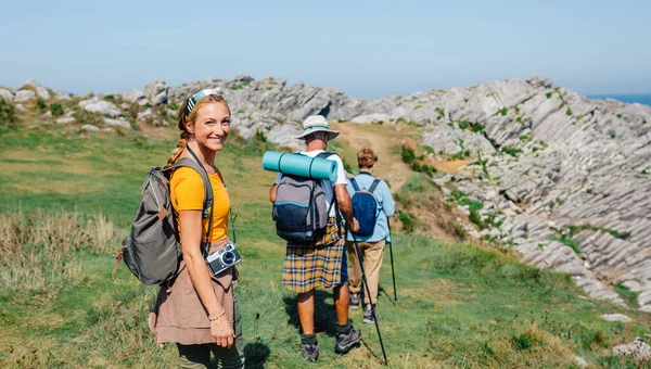 Happy young woman looking camera hiking with her grandparents — Stock Photo, Image