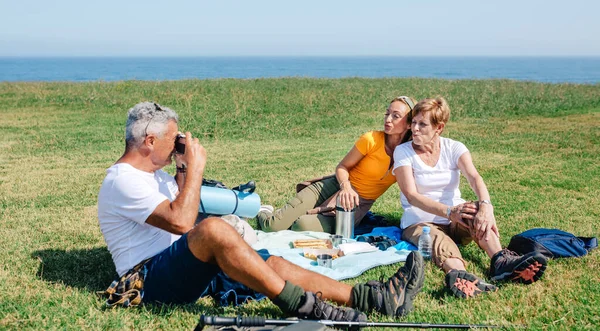 Père aîné prenant une photo de sa famille avec le visage de canard assis sur une couverture pique-nique — Photo