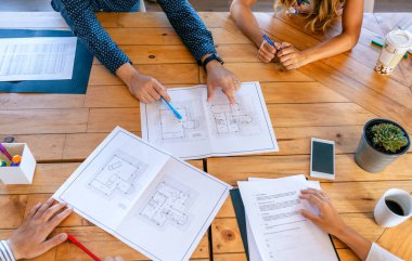 İnşaat planlarına bakan tanınmayan mimarların üst görüşü