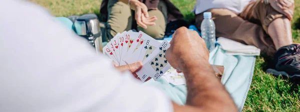 Famiglia adulta irriconoscibile che gioca a carte durante un'escursione — Foto Stock