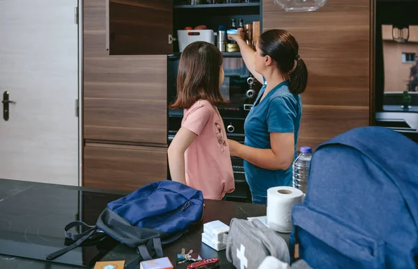 Madre preparando mochila de emergencia con su hija — Foto de Stock