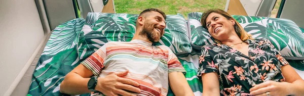 Paar kijkend naar elkaar liggend op het bed van hun camper — Stockfoto