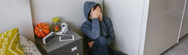 Deprimerad manlig tonåring som sitter på golvet i sitt sovrum — Stockfoto