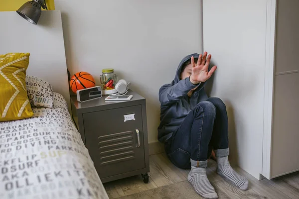 Malheureux solitaire garçon adolescent assis sur le sol dans sa chambre à coucher refusant l'aide avec sa main — Photo
