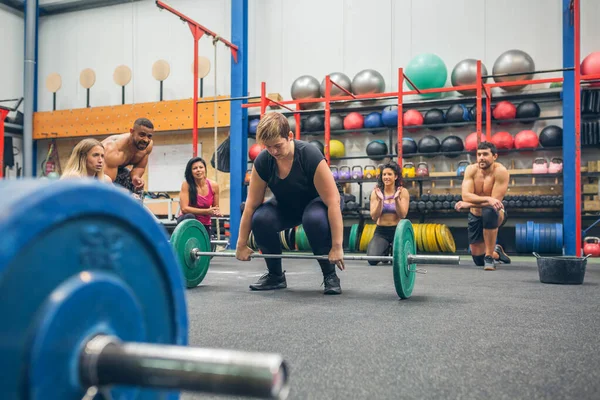 Woman ready to do weightlifting while her gym mates cheering her on — Stock Photo, Image