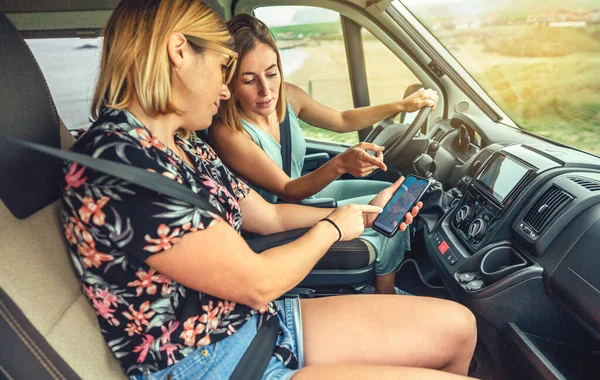 Friends looking gps on the mobile during a campervan trip — ストック写真
