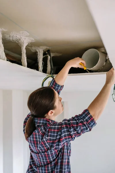 Woman placing tube for kitchen hood installation — Stock Photo, Image