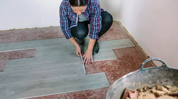 女砖工测量瓷砖以安装地板 — 图库照片