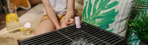 Girl camping at home roasting marshmallows — Stock Photo, Image