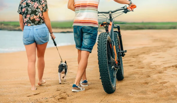 Unrecognizable couple with a fat bike taking a walk on the beach — стоковое фото
