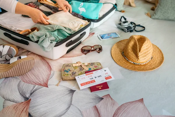 Неузнаваемая женщина готовит чемодан к летним каникулам — стоковое фото