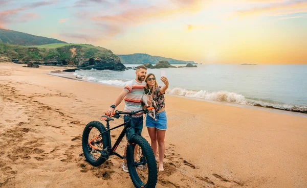 Couple with fat bike taking a selfie with their dog on the beach — Stock Photo, Image