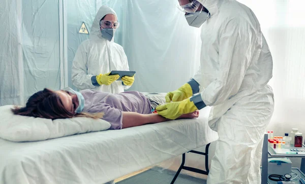 Médicos Terno Proteção Bacteriológica Tomando Amostra Sangue Paciente Deitado Uma — Fotografia de Stock