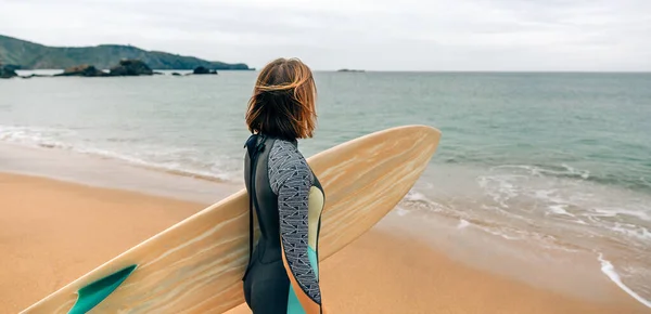 Unrecognizable Young Surfer Woman Wetsuit Carrying Surfboard Looking Sea Beach — Stock fotografie