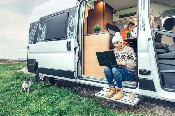 Woman Teleworking Sitting Door Camper Van While Her Partner Works — Stockfoto