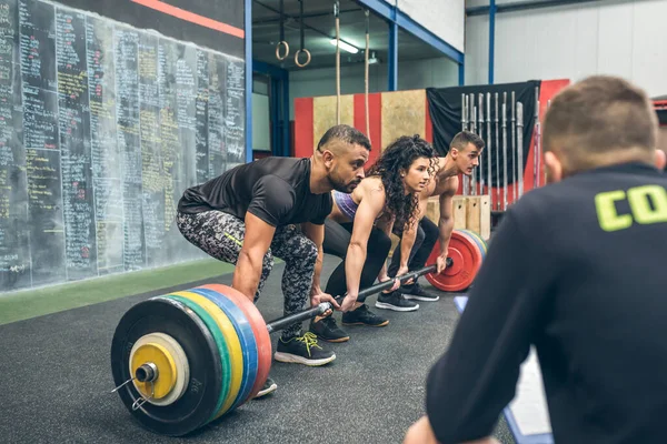 Equipo Mixto Levantando Pesas Gimnasio Mientras Entrenador Los Observa — Foto de Stock