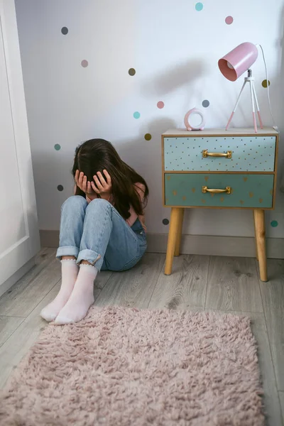 Nierozpoznawalna Przygnębiona Dziewczynka Zakrywająca Twarz Dłońmi Siedzącymi Podłodze Sypialni — Zdjęcie stockowe