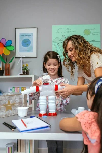 Teacher Ecology Classroom Helping Girl Make Recycled Toy Robot Plastic — Stock Photo, Image