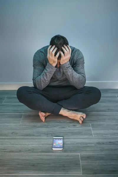 Hombre Irreconocible Con Problemas Cubriendo Cara Sentado Suelo Detrás Móvil —  Fotos de Stock