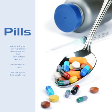 Gümüş kaşık içinde çeşitli renklerde tıp hapları