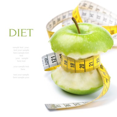 Green apple core and measuring tape. Diet concept